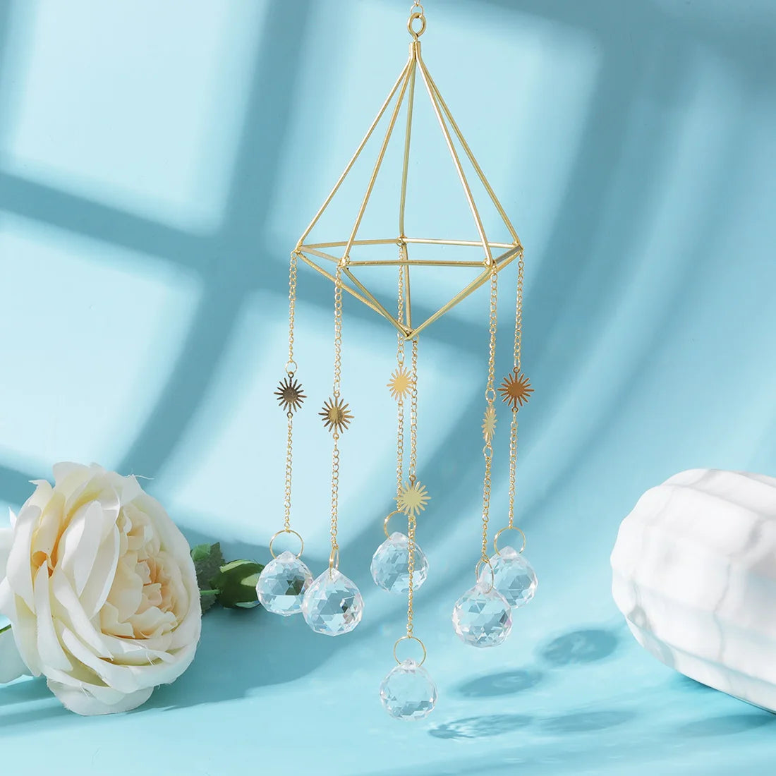 Decorative hanging crystal with gold accents on a light blue background