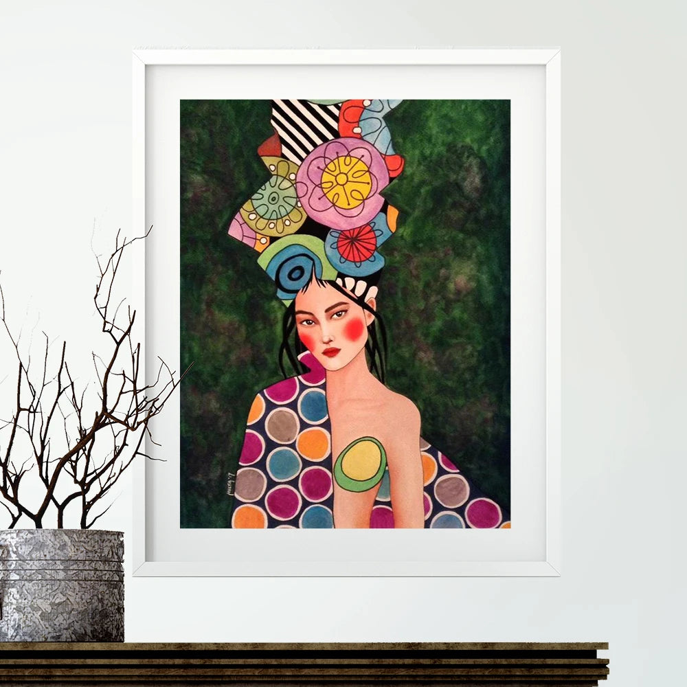 Framed artwork of a woman with a colorful headpiece and polka dot dress on a white wall.