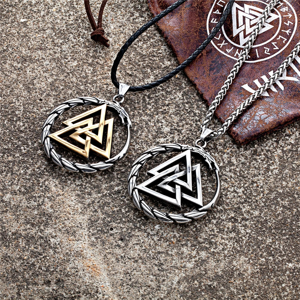 Two Viking-style necklaces with intricate designs on a stone surface.