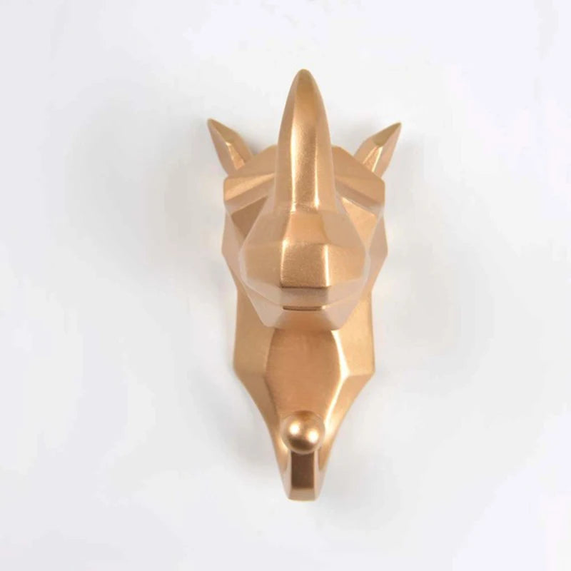 Gold metallic wall hook shaped like a rhino head on a white background