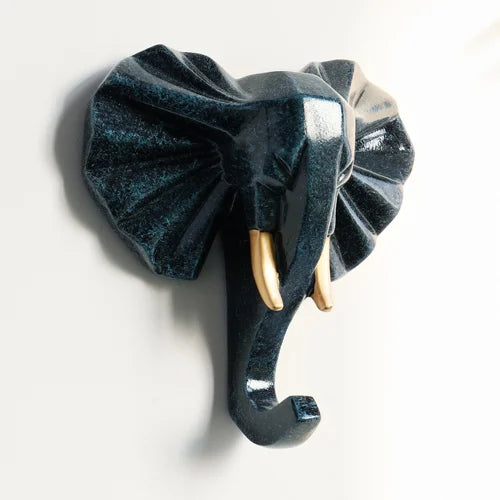 Decorative elephant head wall hook with gold tusks on a white background