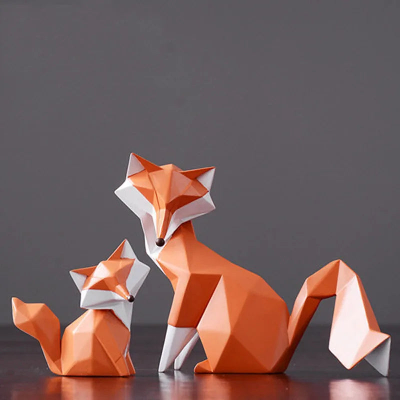 Two orange geometric fox figures on a dark surface with a gray background