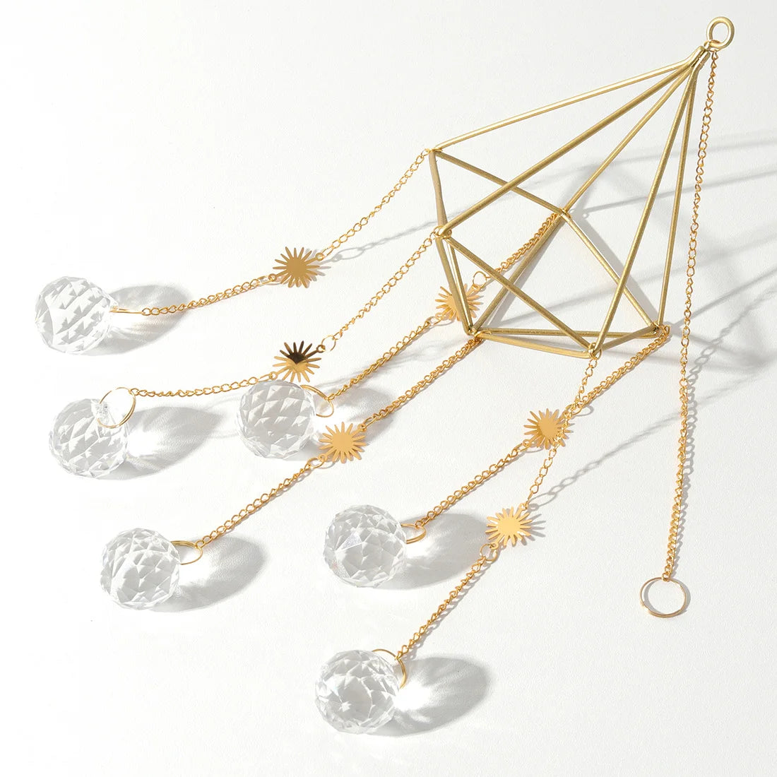 Decorative hanging crystal with gold chain and geometric design on a white background