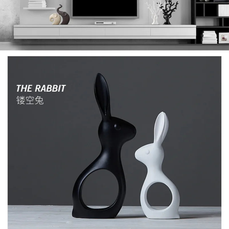 Black and white rabbit sculptures on a gray surface with a dark background.