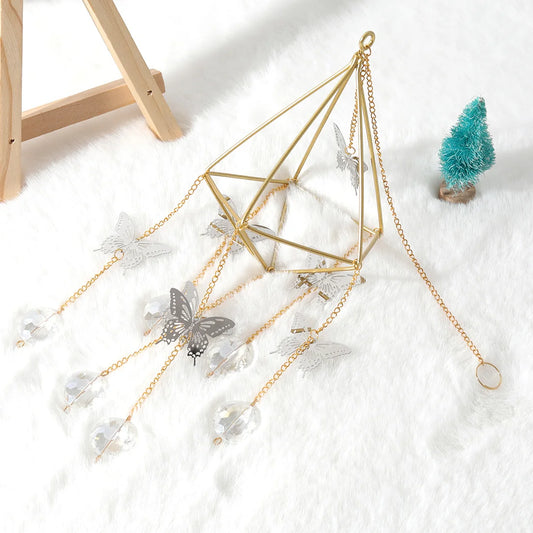 Decorative geometric pyramid with crystals and butterflies on a white surface