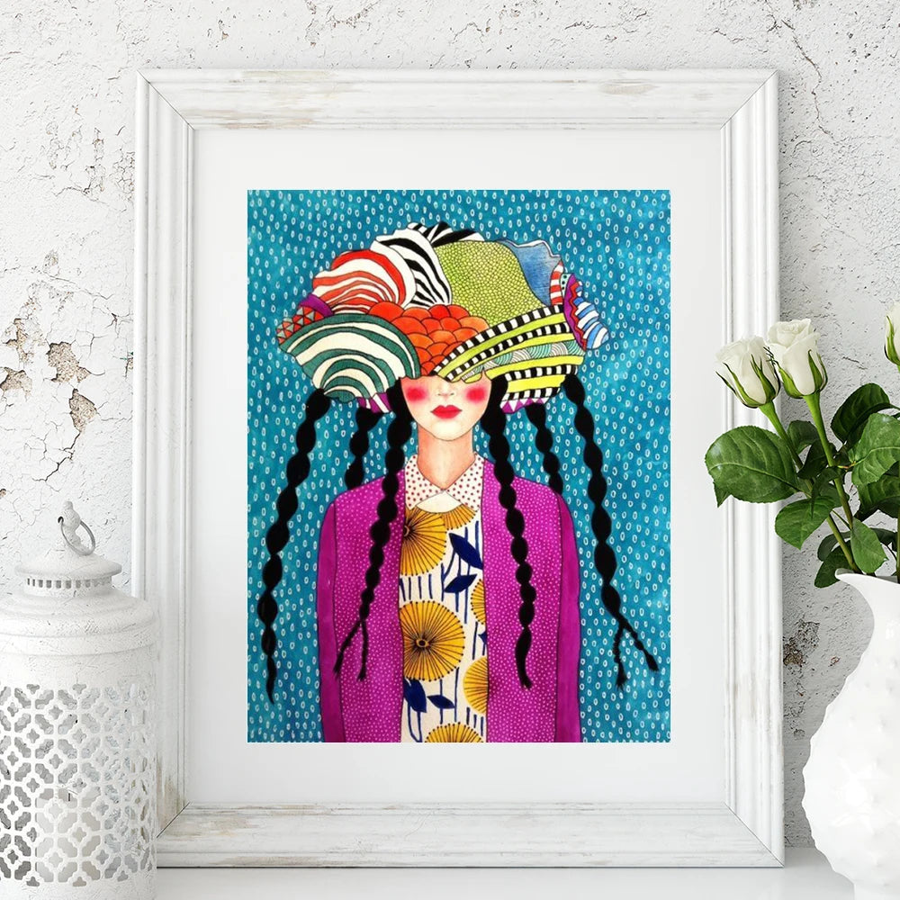 Framed artwork of a woman with a colorful hat and braided hair against a blue polka dot background.
