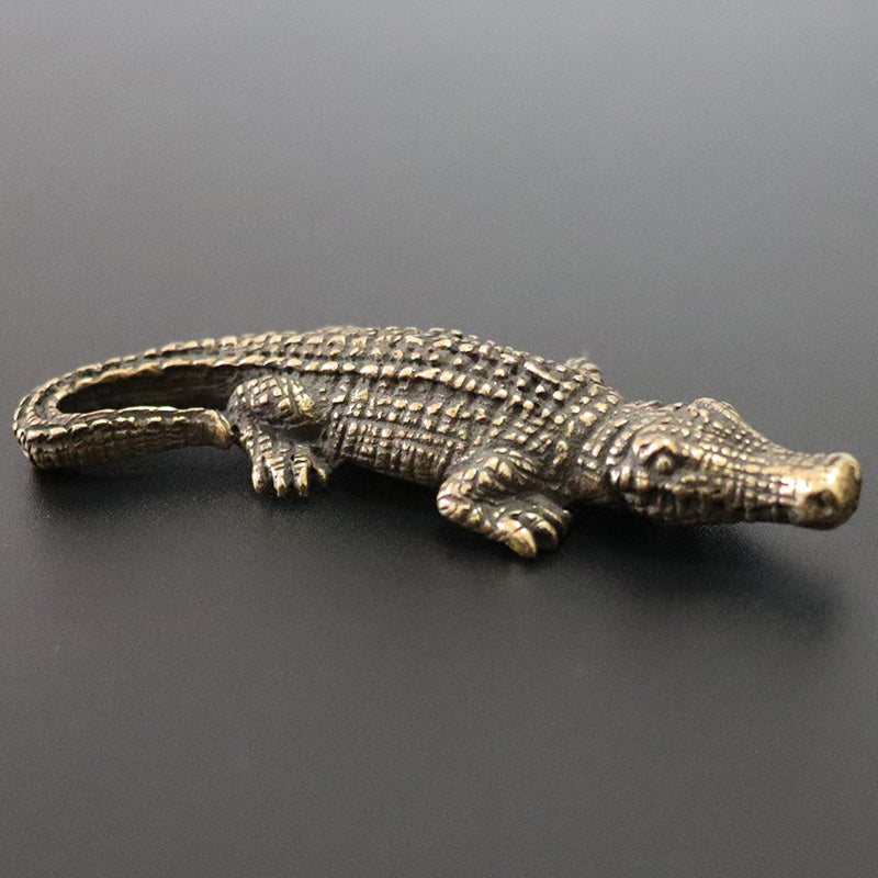 Bronze alligator figurine on a dark gray background
