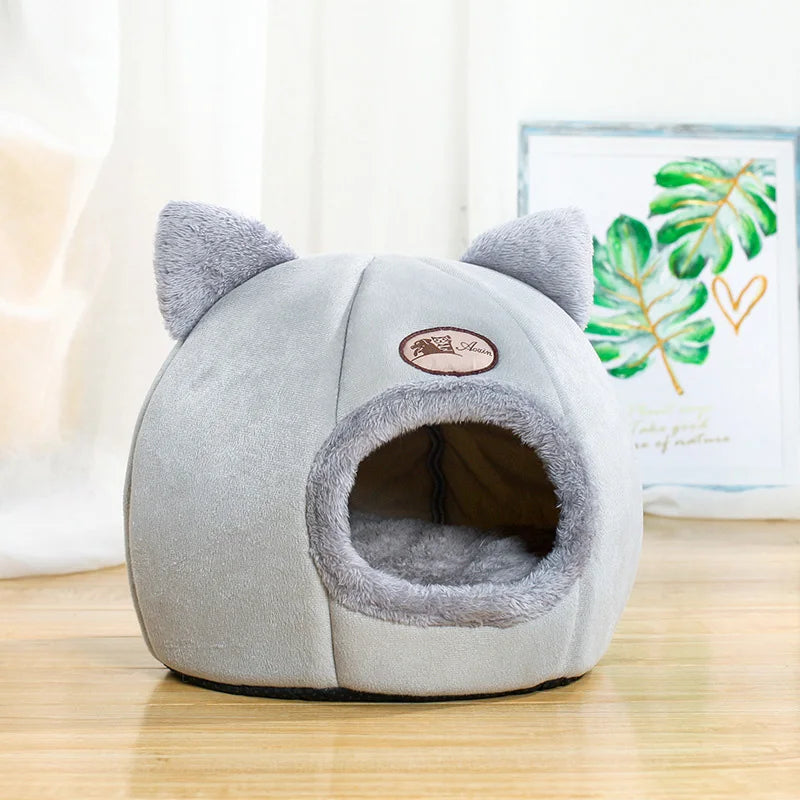 Gray pet bed with ears on a wooden floor