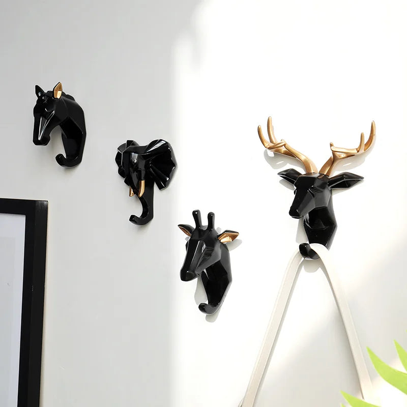 Set of animal-themed wall hooks on a white wall.
