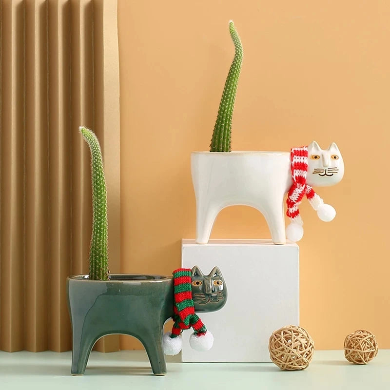 Cream white and dark green ceramic cat plant pots showing approximate dimensions of 15 cm wide and 9 cm high.