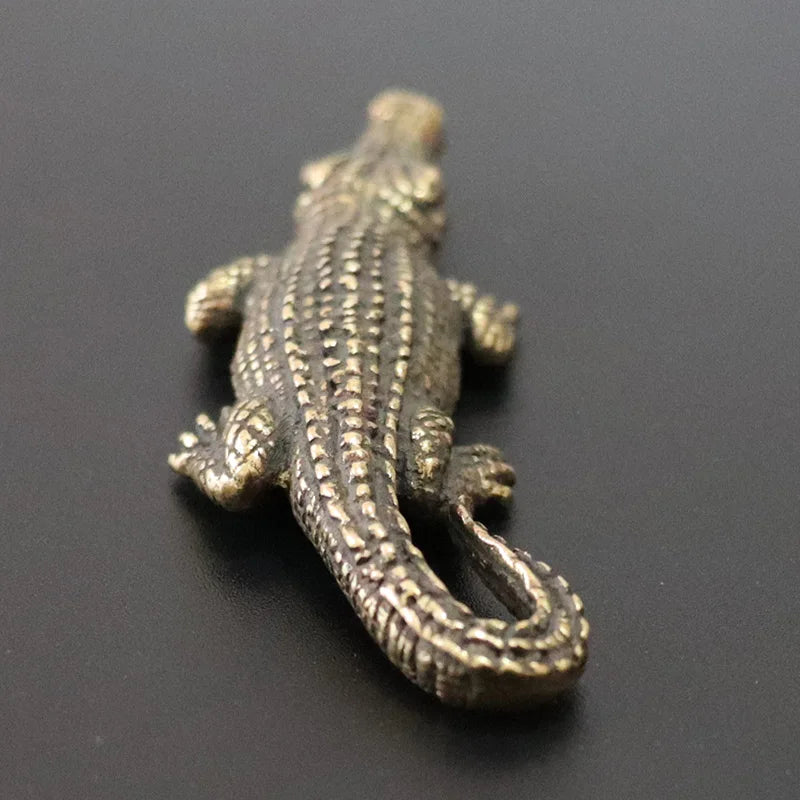 Bronze alligator figurine on a black background