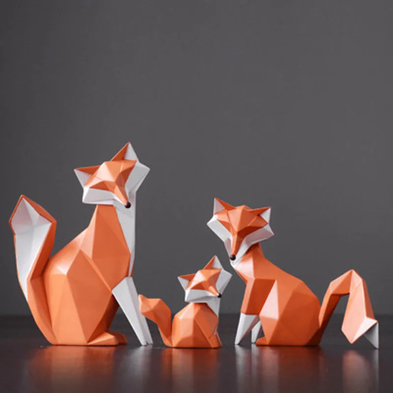Three geometric fox figurines on a reflective surface with a dark background