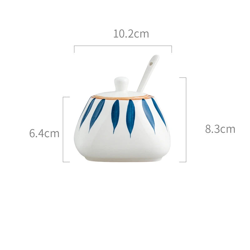 Ceramic container with blue leaf patterns and a spoon, shown with dimensions on a white background.