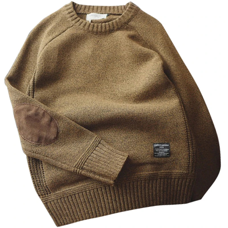 Brown sweater with a brand label on a white background