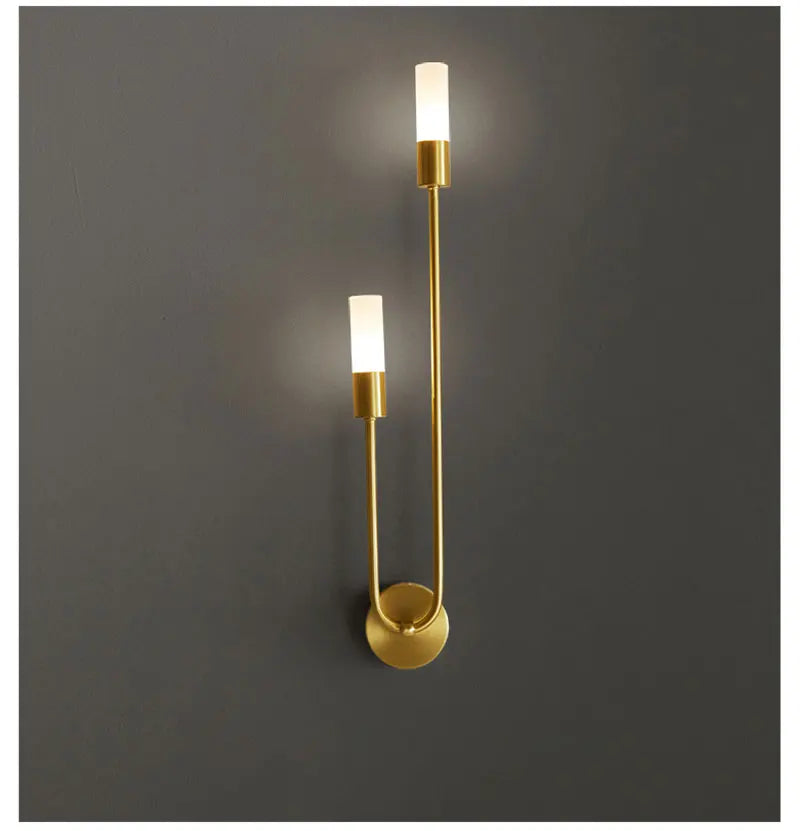 Gold wall sconce with two lights on a dark gray background