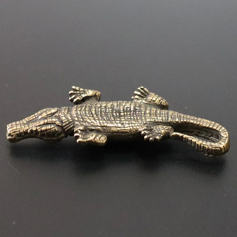 Bronze alligator figurine on a black background