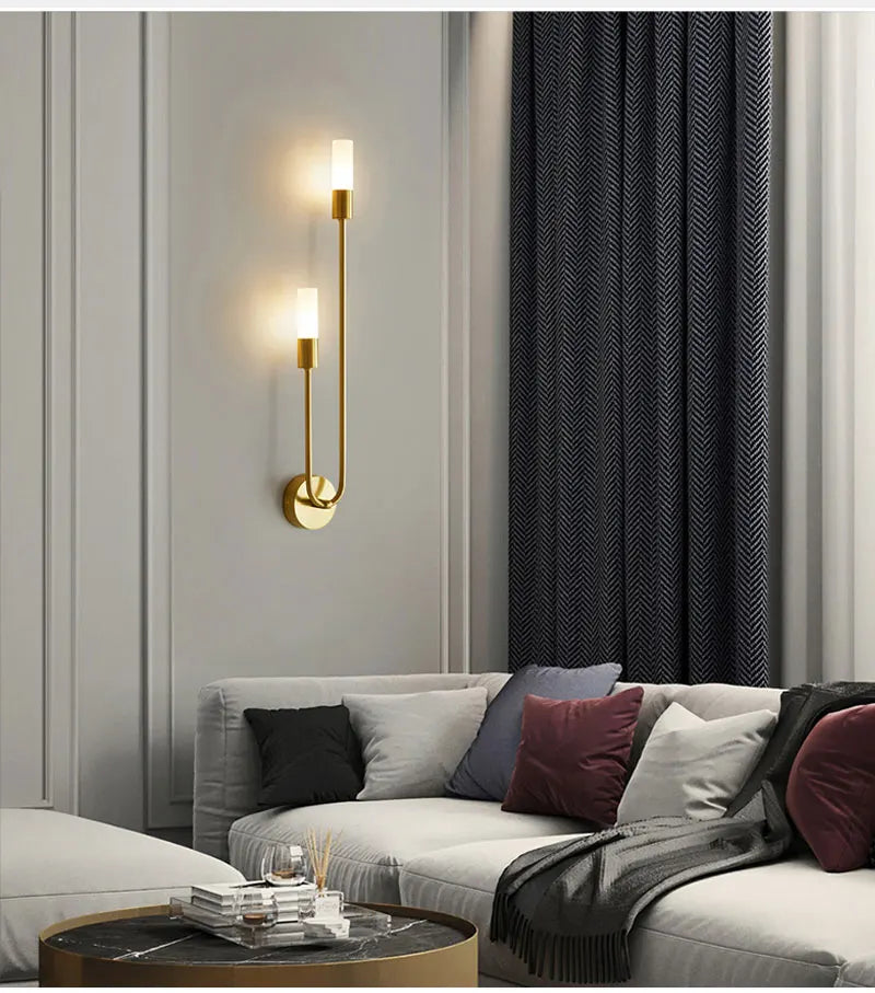 Modern living room with a sectional sofa, wall sconces, and dark curtains.