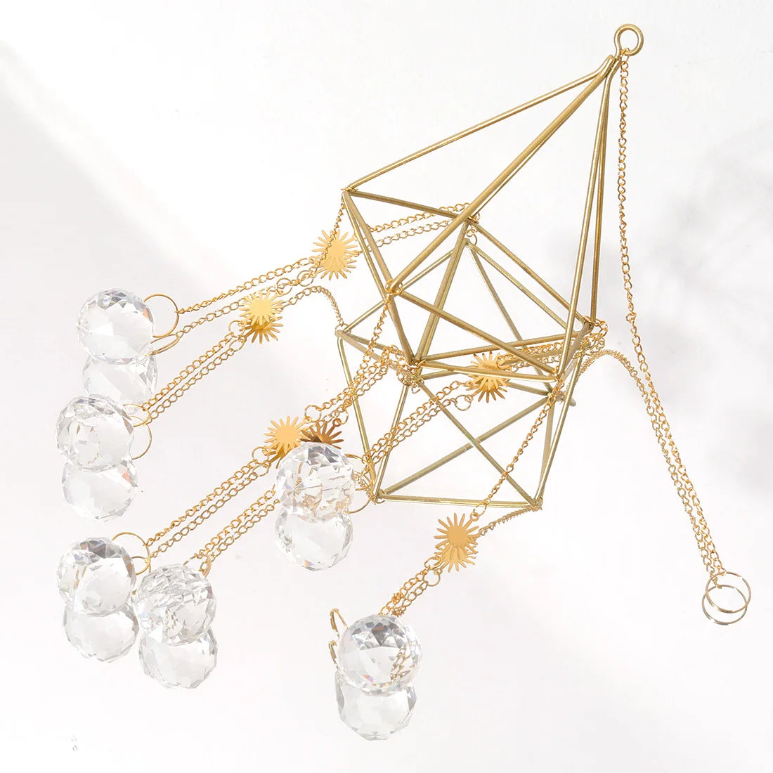 Decorative hanging crystal and gold geometric design on a white background
