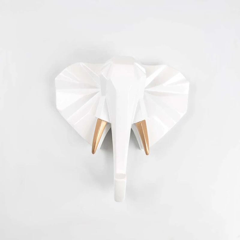 White elephant-shaped wall hooks with gold accents on a light gray background