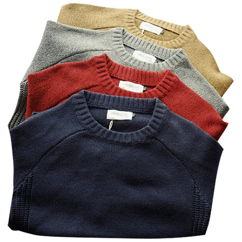 Four folded sweaters in navy, red, gray, and beige on a white background