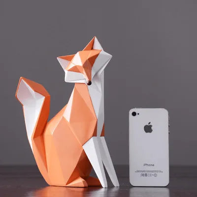 Geometric fox sculpture next to an iPhone on a dark surface with a gray background