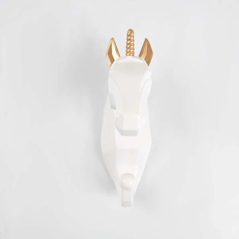 White unicorn hook with gold horns on a light gray background
