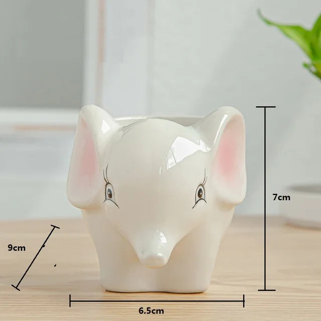 White ceramic elephantplanter with measurements on a wooden surface