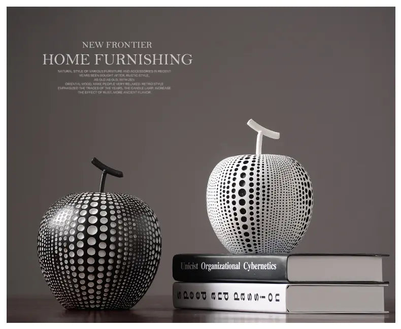 Decorative apple sculptures on books with 'New Frontier Home Furnishing' text in the background