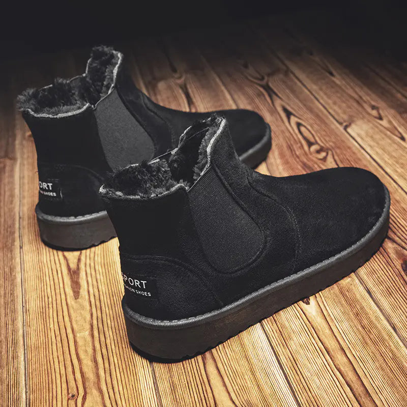 Black ankle boots with fur lining on a wooden floor