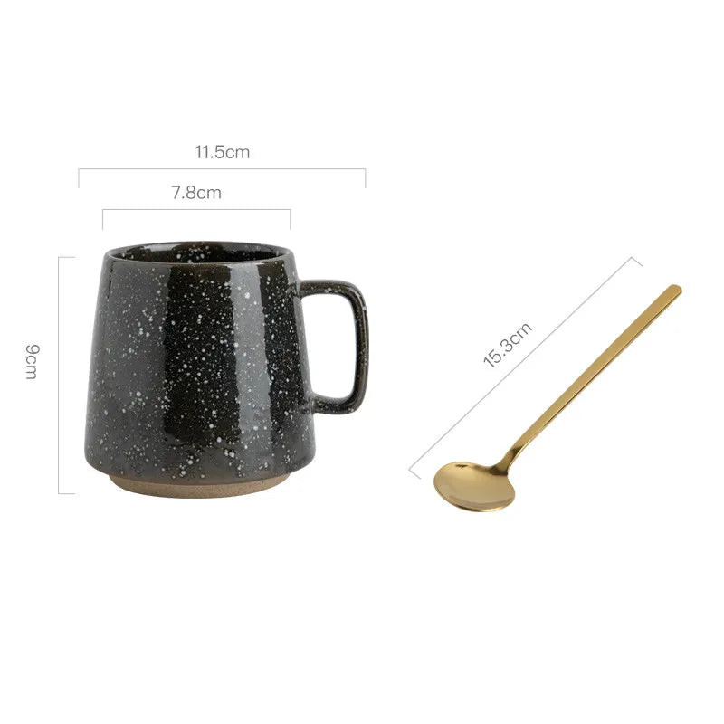 Black speckled mug and gold spoon with measurements on a white background