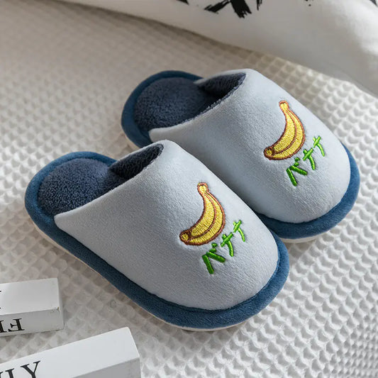 Pair of children's slippers with banana design on a textured surface