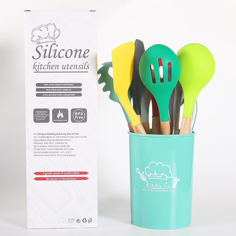 Set of colorful silicone kitchen utensils in a turquoise holder with packaging on a white background