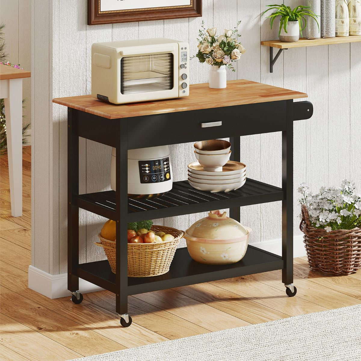 Black kitchen cart with wooden top holding kitchen items in a home setting.