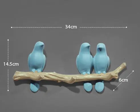 Three blue bird figurines on a branch with measurements indicated.