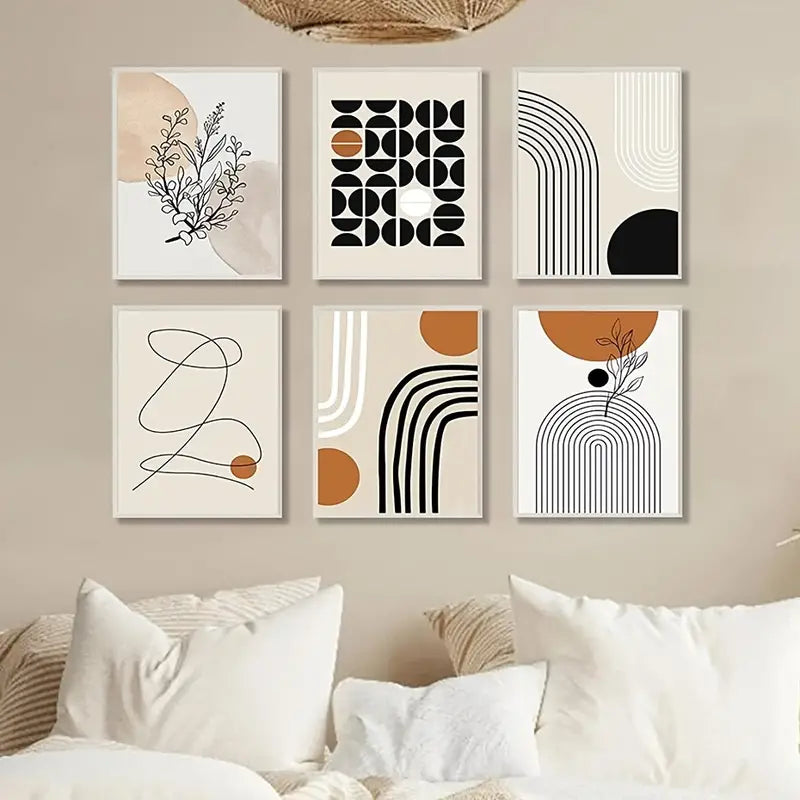 Set of abstract art prints on a wall over a bed with loads of pillows