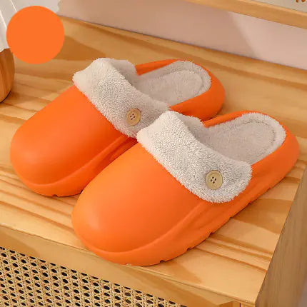 Orange slippers with white fur lining on a wooden surface