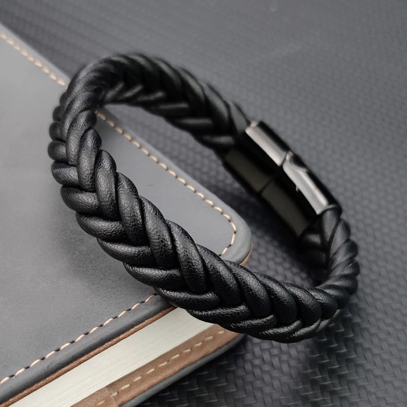 Black braided leather bracelet on a textured surface