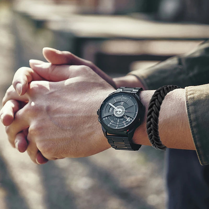 Person wearing a black wristwatch and a Black braided leather bracelet with magnetic clasp with a blurred background