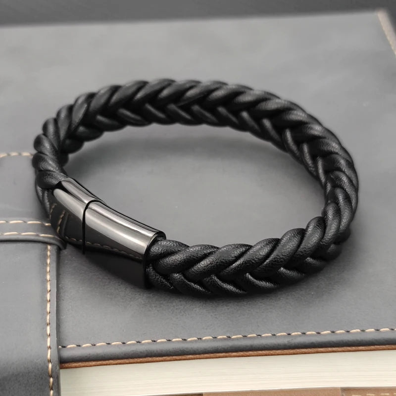 Black braided leather bracelet with a silver clasp on a gray textured surface