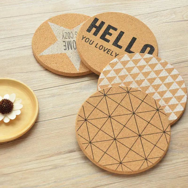 Set of cork coasters with different designs on a wooden surface