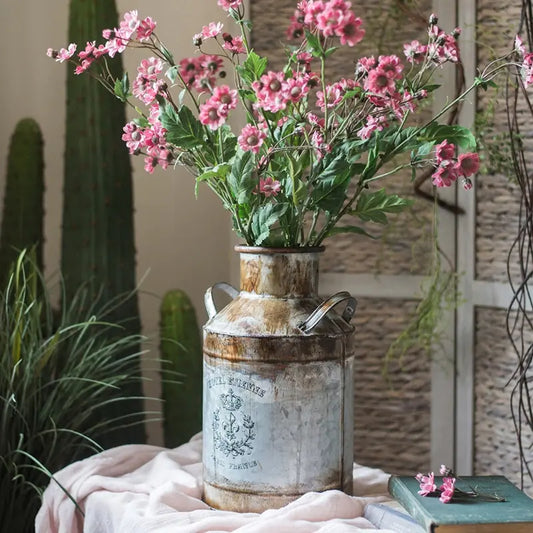 Vintage-style vase with pink flowers on a textured surface
