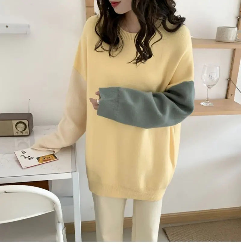Person wearing a yellow and gray sweater in a room with a table and chair.