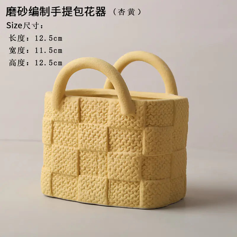 Yellow textured handbag-style flower pot on a light gray background