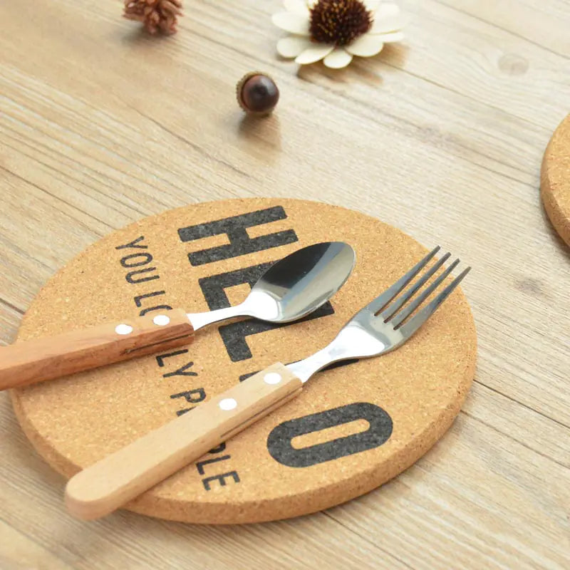 Cork coaster with cutlery on a wooden surface