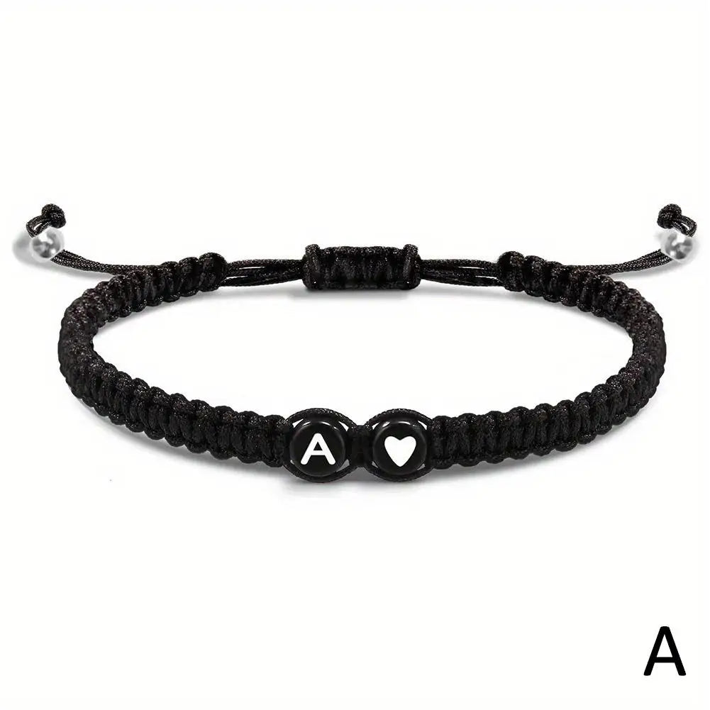 Black braided bracelet with letter 'A' and heart charm on a white background