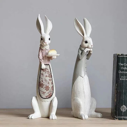 Set of decorative rabbit figurines on a wooden surface with a gray background