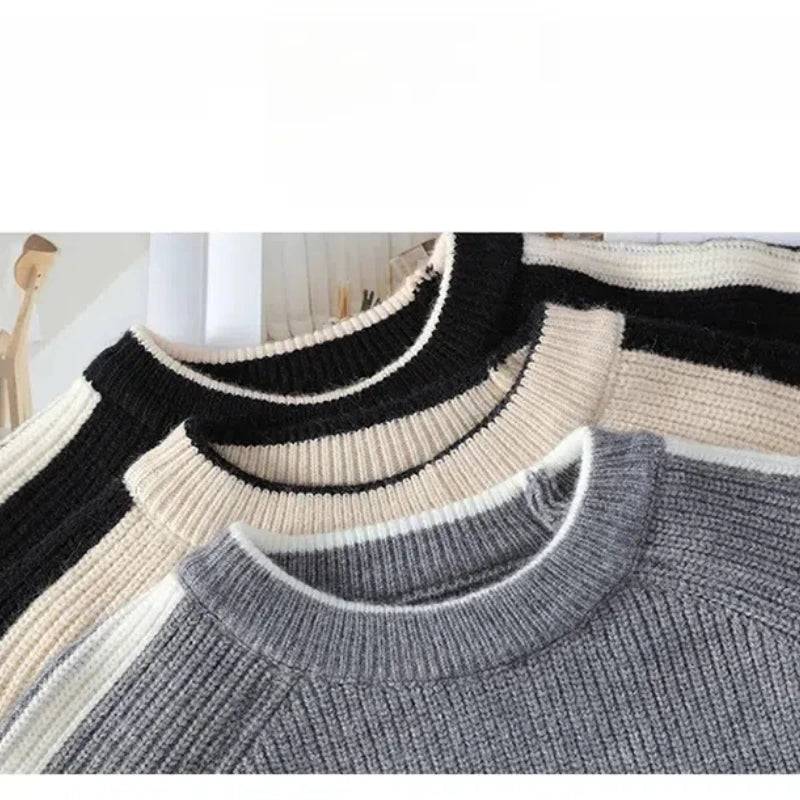 Three sweaters in black, beige, and gray on a white background