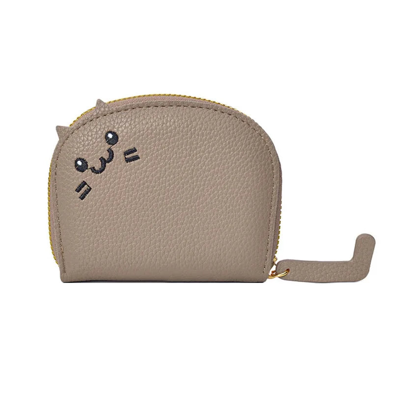 Beige coin purse with cat face design on a white background