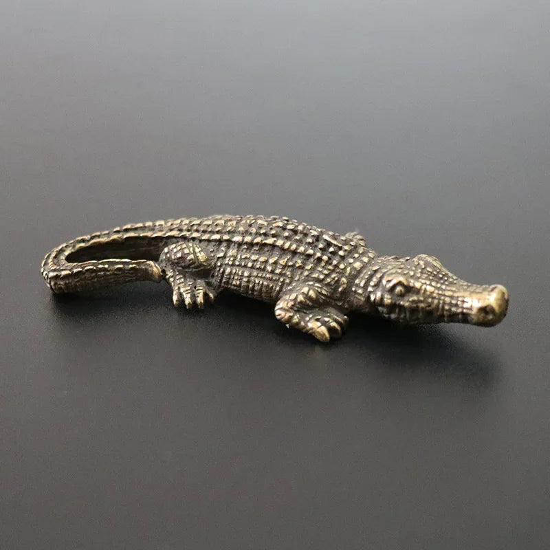 Bronze alligator figurine on a dark gray background