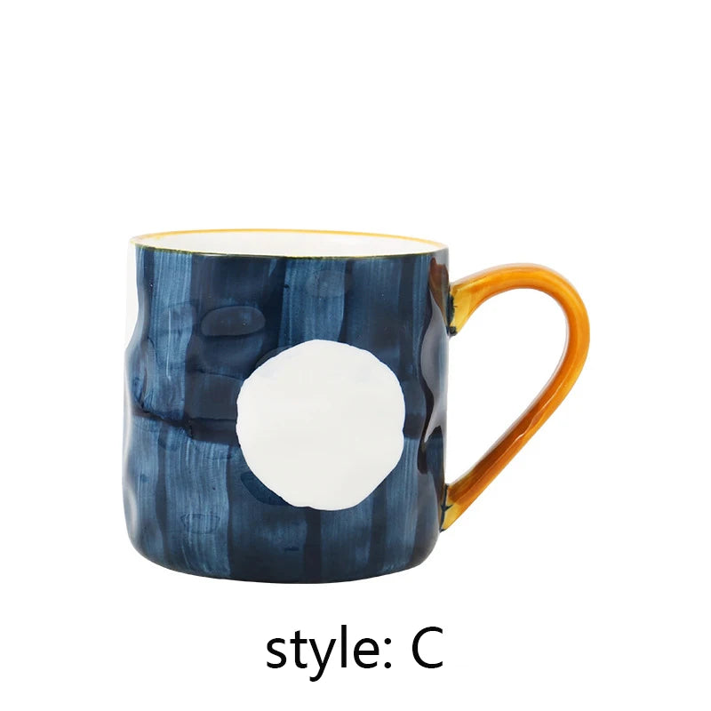 Mug with blue abstract design and orange handle on a white background